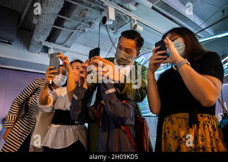 Hong Kong, Chine.8 octobre 2021.Les visiteurs utilisent la réalité augmentée (AR) avec leurs smartphones pour interagir avec différentes œuvres d'art lors de la Foire d'art numérique en Asie à Hong Kong, en Chine, le 08 octobre 2021.La foire présente NFT Crypto Art, jetons non fongibles, dans le cadre de la nouvelle tendance de l'art moderne (Credit image: © Miguel Candela/SOPA Images via ZUMA Press Wire) Banque D'Images