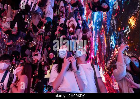 Hong Kong, Chine.8 octobre 2021.Les gens visitent et prennent des photos de l'installation d'art immersive intitulée 'l'espace d'hallucinations de machine : métaverse par l'artiste numérique de nouveaux médias turc-américain Refik Anadol à la Foire d'art numérique Asie à Hong Kong, Chine, le 08 octobre 2021.La foire présente NFT Crypto Art, jetons non fongibles, dans le cadre de la nouvelle tendance de l'art moderne (Credit image: © Miguel Candela/SOPA Images via ZUMA Press Wire) Banque D'Images