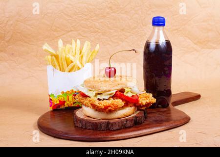 Hamburger de poisson juteux, hamburger ou cheeseburger avec une galette de poisson, avec sauce frites et boisson froide.Concept de restauration rapide américaine.Copier l'espace Banque D'Images