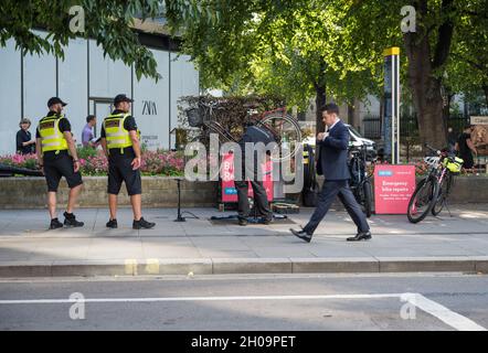 Mécanicien travaillant sur un vélo dans un stand de réparation de vélo de la police de la ville de Londres à Cheapside, Londres, Angleterre, Royaume-Uni Banque D'Images