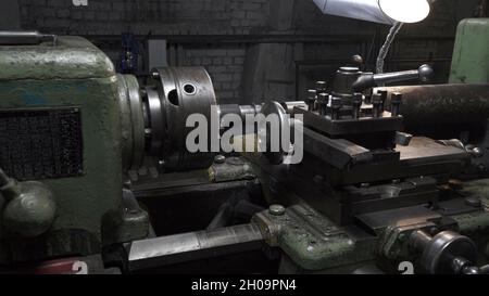 Processus de travail avec détails métalliques sur le tour sur le lieu de travail Banque D'Images