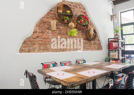 décor de géraniums, d'aliments séchés et de farines anciennes sur des étagères sur un mur en brique rouge. Banque D'Images