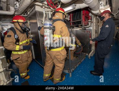 OCÉAN PACIFIQUE (janv1, 2021) – les marins américains réagissent à un incendie simulé lors d'un exercice de contrôle des dommages à bord du croiseur à missiles guidés de classe Ticonderoga USS Bunker Hill (CG 52) le 1er janvier 2021.Bunker Hill est en cours de déploiement prévu avec le Theodore Roosevelt Carrier Strike Group qui effectue des opérations de routine dans la zone d'opérations de la troisième flotte des États-Unis. Banque D'Images