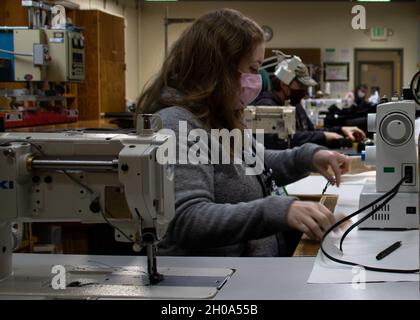 Silverdale, Washington (janv8, 2021) - Kelsey Haley, Trident Revit Facility Bangor (TRFB) Fabric Worker, fabrique des revêtements COVID-19 dans le loft à voile TRFB (Shop 74A).Depuis avril 2020, le Sail Loft a fabriqué six revêtements d'essai de bioenceinte COVID-19 pour le Groupe sous-marin 9 et plus de 4,000 revêtements de visage pour l'effectif de TRFB.Le Sail Loft se compose de cinq employés et d'un superviseur.Les tâches typiques incluent le garnissage, l'applique, la broderie, les revêtements de machines/équipements, les sacs à outils et sacs à dos personnalisés, les rideaux, les contentions de passage, les sacs à gants, les canopies de bateau,et auvents Banque D'Images