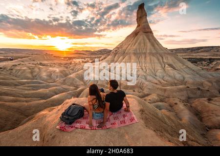 Un jeune homme et une jeune femme regardant le coucher du soleil à Castildetierra dans le désert de Bardenas Reales, Navarre, pays Basque. Banque D'Images