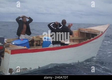 L'équipage de la Garde côtière Cutter Heriberto Hernandez interdicte un bateau de fortune avec trois ressortissants de la République dominicaine dans le passage de Mona le 5 janvier 2021.L'un des hommes était un fugitif avec un mandat permanent pour un meurtre présumé qui a été transféré à la garde des agents des Marshals américains à Mayaguez, Porto Rico le 7 janvier 2021.Les deux autres hommes ont été transférés à un bateau de patrouille de la marine de la République dominicaine pour leur retour en République dominicaine. Banque D'Images