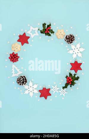 Couronne de Noël minimaliste abstraite avec décorations d'arbre, houx, tartes de viande hachées et flocons de neige.Composition pour Noël et nouvel an.Sur fond bleu pastel Banque D'Images