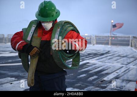 Le marin Reed Carlson, un membre de l'équipage à bord de la vedette de la Garde côtière Polar Star (WABG 10), le seul brise-glace lourd du pays, transporte des élingues de grue après avoir chargé de la nourriture et des fournitures à bord de la découpeuse lors d'un arrêt logistique dans le port hollandais, en Alaska, le mercredi 6 janvier 2021.L'équipage stationné à bord du brise-glace lourd de 44 ans est d'environ 30 jours dans une patrouille d'un mois pour projeter l'énergie et soutenir les objectifs de sécurité nationale dans les eaux de l'Alaska et dans l'Arctique, y compris le long de la ligne de démarcation maritime entre les États-Unis et la Russie. Banque D'Images