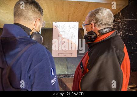 Un membre de la police fédérale belge et un instructeur de tir affecté au siège suprême des puissances alliées en Europe évaluent une cible au centre de soutien à la formation de 25 mètres, sur la base aérienne de Chièvres, Belgique, le 7 janvier 2021. Banque D'Images