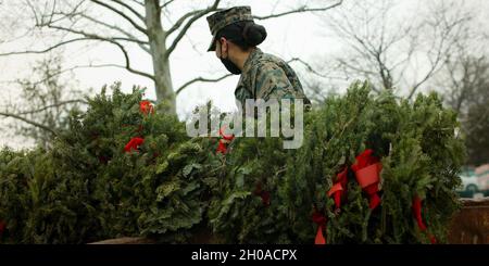 Les Marines des États-Unis se joignent aux soldats, aux marins et aux aviateurs pour ramasser et éliminer des couronnes au cimetière national d'Arlington, en Virginie. Le cimetière était l'un des 2,000 endroits où des couronnes ont été posées en décembre sur des pierres tombales d'anciens combattants dans l'observance annuelle de leur service et de leurs sacrifices. Banque D'Images