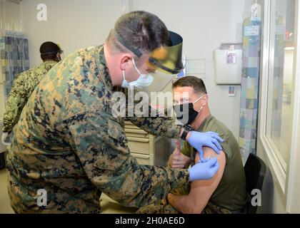 KINGS BAY, Géorgie (janv8, 2021) le lieutenant-colonel Michael Weber, commandant du bataillon de la force de sécurité du corps maritime, reçoit la première dose du vaccin COVID-19 de l'hôpital Corpsman de 1re classe Matthew Thompson à la clinique de santé de la branche navale à bord de la base sous-marine de Kings Bay, en Géorgie, le 8 janvier.Le personnel médical, les premiers intervenants et les forces stratégiques ont été parmi les premiers à recevoir le vaccin. Banque D'Images