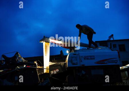 (211012) -- GUIYANG, 12 octobre 2021 (Xinhua) -- Zhao Xiangrong est photographié sur une moissonneuse dans le village Leping du comté de Majiang, dans la province de Guizhou, au sud-ouest de la Chine, le 8 octobre 2021.Zhao Xiangrong, ancien chauffeur de camion et chef, est retourné dans sa ville natale de Guizhou et a commencé à planter du riz en 2015.Soutenu et guidé par le gouvernement local et des experts, Zhao a développé des compétences dans la culture du riz contenant du zinc, du sélénium et d'autres microéléments.Après six années de dur labeur, Zhao a accumulé une riche expérience dans le semis des semences, la gestion des champs, ainsi que la transformation, le transport et le stockage de Banque D'Images