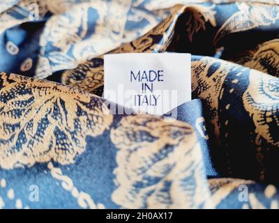 Gros plan d'une étiquette « Made in Italy » sur un fond bleu avec un arrière-plan flou Banque D'Images