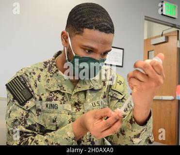 L'Hospitalman Jaylen King, un responsable d'hôpital affecté à la préparation à la médecine de la Marine et au commandement de formation Corpus Christi prépare une seringue avec le vaccin Moderna COVID-19 lors d'un tir-ex à la station aérienne du secteur de la Garde côtière américaine Corpus Christi, Texas.Le CCNMR suit le plan de distribution du vaccin COVID-19 du DoD afin de mettre en œuvre une stratégie progressive pour administrer le vaccin afin de protéger notre force de combat et de maintenir son état de préparation.Actuellement, le vaccin n'est disponible que pour les membres du service, les civils DOD et les autres employés qui remplissent des fonctions essentielles comme les soins de santé et les services d'urgence Banque D'Images