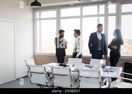 Silhouettes de personnes contre la fenêtre. Une équipe de jeunes hommes d'affaires travaillant et communiquant ensemble dans un bureau. Affaires professionnelles et Banque D'Images