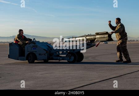 Les chargeurs d'armes du 57e Escadron de maintenance participent à une compétition d'équipage de charge de l'année à la base aérienne de Nellis, Nevada, le 14 janvier 2021.Les aviateurs devaient travailler en équipe pour charger rapidement et efficacement des armes dans les avions. Banque D'Images