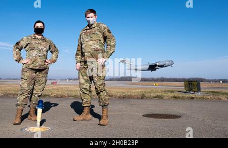 Le premier Airman Kristina Grafton, le 436e Escadron de soutien aux opérations, le superviseur des opérations de gestion de terrain d'aviation, et le premier Airman Keyton Nickell, le 436e Escadron de soutien aux opérations de terrain d'aviation, le chef de service de gestion de terrain d'aviation, posent pour une photo en tant que C-17 Globemaster III quitte la base aérienne de Douvres, Delaware, le 14 janvier 2021.Après le lancement différé de Total Force Training Records, Grafton a construit un tracker d’entraînement numérique, qui a été distribué à 133 autres bases par l’Agence des normes de vol de la Force aérienne à titre de norme provisoire du domaine de la gestion des carrières dans les terrains d’aviation pour la documentation de formation. Banque D'Images