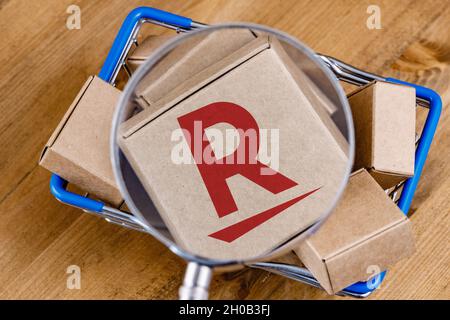Photo modifiée du logo Rakuten sur une boîte sous la loupe dans le panier. Banque D'Images