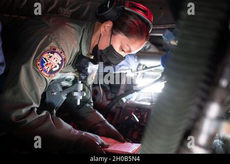 Tech.Sgt.Gina Cavaco, exploitant de la rampe du 203e Escadron de ravitaillement en vol, remplit une liste de contrôle préalable au vol à l’intérieur d’une «rampe» du KC-135 Stratotanker le 15 janvier 2021, à la base conjointe Pearl-Harbour Hickam, à Hawaï.L'équipage de la Garde aérienne nationale d'Hawaï a transporté environ 200 gardes de bord d'Hawaï à Washington D.C. pour fournir un soutien aux missions de sécurité, de communication et de logistique pour la 59ème inauguration présidentielle. Banque D'Images