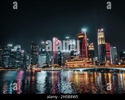 SINGAPOUR, SINGAPOUR - 28 septembre 2019 : un paysage de magnifiques gratte-ciels modernes entourés d'eau la nuit à Singapour Banque D'Images