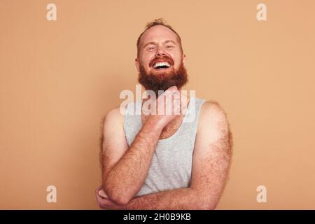 Homme joyeux souriant à la caméra dans un studio.Corps positif jeune homme debout contre un arrière-plan de studio.Auto-assuré jeune homme se sentant réconfortant Banque D'Images