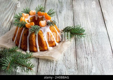 Gâteau de Noël fait maison avec fruits confits, orné de tranches de mandarine et de branches de sapin.Noël fête du nouvel an concept sur W Banque D'Images