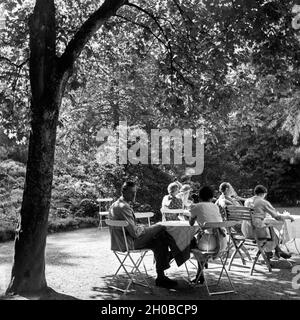 Männer und Frauen un Außengastronomie sitzen und Tischen bei Triberg im Schwarzwald, Deutschland 1930 er Jahre. Les hommes et les femmes assis sur les tables d'une gastronomie plein air près de Triberg en Forêt-Noire, Allemagne 1930. Banque D'Images