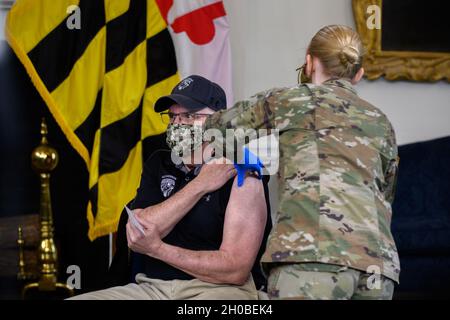 SPC.Alexis Ruth, spécialiste en médecine du détachement médical de la Garde nationale du Maryland, administre le vaccin COVID-19 initial à Gov.Larry Hogan le 18 janvier 2021, à la maison d'État du Maryland, à Annapolis, au Maryland. Des membres du MDNG Medical Detachment et du 224e Medical Company Area support ont administré les vaccins à Hogan, au lieutenant Gov.Boyd K. Rutherford, leurs épouses, et le Dr Jinlene Chan, secrétaire adjointe à la Santé du Maryland.Les soldats et les aviateurs du MDNG appuient l'initiative de vaccination COVID-19 de Hogan par des équipes mobiles de soutien à la vaccination, qui fournissent un soutien médical et logistique à Th Banque D'Images