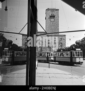 Straßenbahn der Linie 6 spiegelt sich von Tabakwarengeschäfts Schaufensterscheibe in der am Hauptbahnhof à Stuttgart, Deutschland 1930er Jahre. La ligne de tram no. 6 en raison de la fenêtre d'un bureau de tabac en face de la gare principale de Stuttgart, Allemagne 1930. Banque D'Images