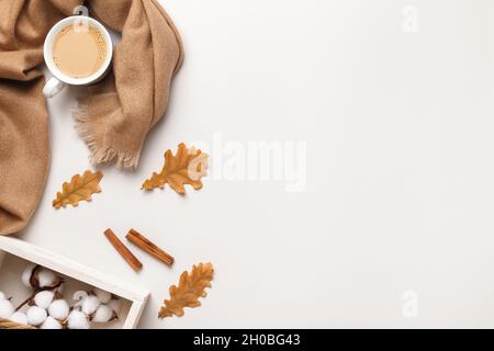 Composition d'automne.Foulard beige en cachemire, une tasse de café avec feuilles de chêne d'automne sur fond gris clair.Espace de copie de la vue de dessus de la pose à plat Banque D'Images