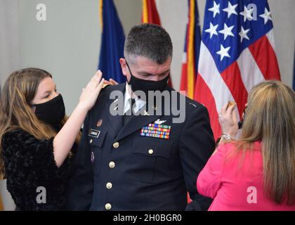 Le colonel Barry Simmons de la Garde nationale de l'Armée de Géorgie reçoit son nouveau rang de sa femme Michelle et de sa fille Allison lors d'une cérémonie de promotion au Centre de la Garde nationale Clay à Marietta, en Géorgie, le 19 janvier 2021. Banque D'Images