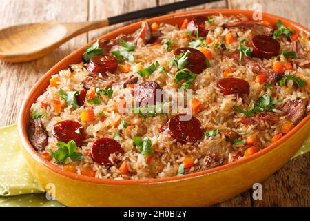 Riz au canard portugais arroz de pato cuit avec du vin rouge, de l'oignon, de la carotte et du chorizo gros plan dans le plat de cuisson sur la table en bois.Horizontale Banque D'Images