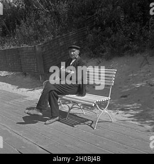 Ein alter Fischer sitzt auf einer Bank bei der Pillkallen Kurischen dans Nehrung Ostpreußen, Deutschland 1930er Jahre. Un vieux pêcheur assis sur un banc près de Pillkallen Courlande à Split dans l'Est de la Prusse, l'Allemagne des années 1930. Banque D'Images