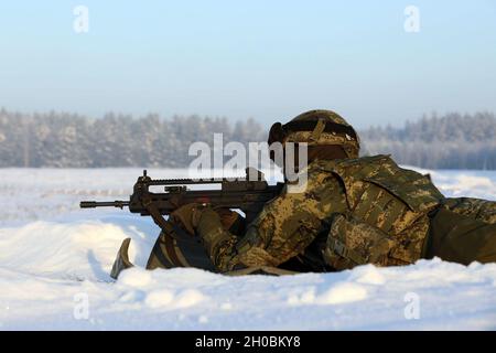 Le soldat de l'armée croate de l'OTAN a renforcé sa présence avancée Groupe de combat-Pologne Volcano Battery tire son fusil pendant une période de qualification d'armes le 19 janvier 2021 à Bemowo Piskie, Pologne. Banque D'Images
