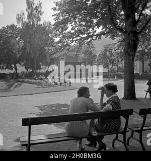 Zwei Frauen auf einer Bank im Kurpark von Herrenalb im Schwarzwald, Deutschland 1930er Jahre. Deux femmes sur un banc dans un parc à Bellingen en Forêt Noire, Allemagne 1930. Banque D'Images