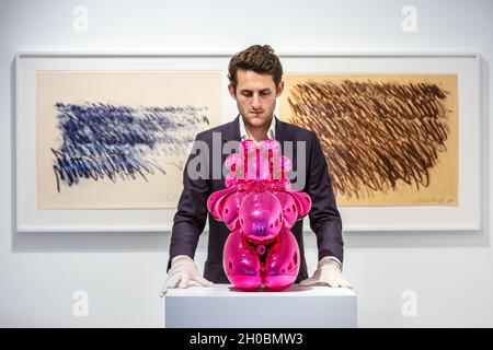 Londres, Royaume-Uni.12 octobre 2021.Le personnel de la galerie avec 'Dom Perignon Balloon venus', par Jeff Coons (2013) et Cy Twombly travaillent sur les murs.Jeff Koons et Cy Twombly :Primal Gestures s'ouvre à la Bastian Gallery de Mayfair, une exposition qui réunit une association très inhabituelle de deux géants de l'art d'après-guerre mettant en évidence deux pratiques apparemment opposées, l'exposition expose le riche lexique visuel de Twombly, qui associe la réalisation de marques et l'abstraction gestuelle à la nature réductrice des fabrications machine de Koons.Credit: Imagetraceur/Alamy Live News Banque D'Images