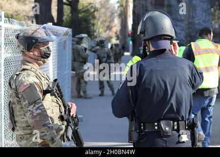 SPC de l'armée américaine.Alexander Kerkeles, de la 270e compagnie de police militaire, 185e Bataillon de police militaire, 49e brigade de police militaire, Garde nationale de l'armée de Californie, discute des opérations avec un officier de patrouille routière de Californie le 20 janvier 2021, au Capitole à Sacramento, en Californie.CAL Guardsmen continue à fournir une sécurité supplémentaire dans les installations fédérales et d'état alors que la nation se prépare à l'investiture du président nouvellement élu Biden. Banque D'Images