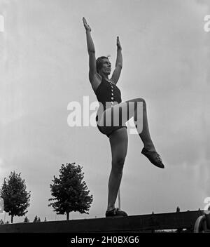 Eine Frau bei einer Übung suis Schwebebalken dans der Logau Musterschule für Frauenturnen à Hannover, Deutschland 1930er Jahre. Une femme faisant un exercice à la poutre à l'école des femmes de Logau gymnastics à Hanovre, Allemagne 1930. Banque D'Images