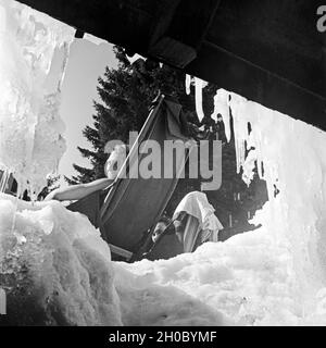 Ein Mann dans un Liegestuhl bei einer Skihütte, Deutschland 1930 er Jahre. Un homme dans une toile président jouissant de ses vacances de ski, Allemagne 1930. Banque D'Images