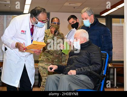 Un professionnel de la santé du ministère des Affaires des anciens combattants passe les écrans Col. (Ret.)Orville Hughes, un vétéran de la Seconde Guerre mondiale âgé de 99 ans, avant de recevoir le vaccin COVID-19, le 30 janvier 2021, au centre médical des anciens combattants de Baltimore, Maryland.Les membres du détachement de préparation médicale de l'État du Maryland, de la Garde nationale du Maryland, ont travaillé avec le ministère des anciens combattants et ont administré des centaines de vaccins aux anciens combattants. Banque D'Images