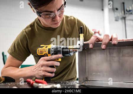 Tech.Sgt.Shelly Pavcik, technicienne en structure d'aéronefs du 911e Escadron de maintenance, fore un trou pour un rivet pour fixer des pièces de métal tout en construisant une boîte d'approvisionnement à la station de réserve aérienne de l'aéroport international de Pittsburgh, Pennsylvanie, le 21 janvier 2021.Des spécialistes de l'entretien des structures fabriquent des pièces métalliques pour diverses réparations d'aéronefs et de véhicules, ainsi que pour des projets de construction sur base. Banque D'Images