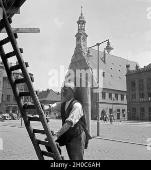 Ein Dachdecker auf dem Weg zu seinem Arbeitsplatz et von Rathaus und Gewandhaus de Zwickau, Deutschland 1930 er Jahre. Un couvreur sur le chemin de son lieu de travail à proximité de la mairie et le Guild Hall à l'ancienne ville de Zwickau, Allemagne 1930. Banque D'Images