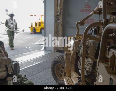 Un Marine, avec la 31e unité expéditionnaire maritime (MEU), conduit un véhicule tout-terrain tactique léger (MRZR) sur le pont de vol pour commencer le chargement sur un Osprey MV-22B avec l'escadron de Tiltrotor moyen marin 262 (renforcé), le 31e MEU, à bord d'un navire d'assaut amphibie America (LHA 6) en mer des Philippines, le 21 janvier, USS2021.Le MRZR a été déployé à l'appui d'un exercice d'entraînement au cours duquel l'élément de commandement avant a été déployé.Le 31e MEU opère à bord des navires du groupe de grève expéditionnaire américain dans la zone d'opérations de la 7e flotte afin d'améliorer l'interopérabilité avec les alliés et les partenaires a Banque D'Images