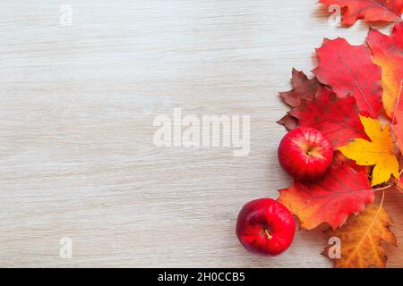 Décoration automnale avec feuilles et pomme rouge sur fond de bois.Composition d'automne à plat avec espace de copie. Banque D'Images