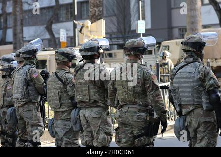 Les gardes nationaux de l’armée de Californie, avec la 270e compagnie de police militaire, le 185e Bataillon de police militaire, 49e brigade de police militaire, comptaient parmi plus de 1,000 soldats citoyens qui aidaient la sécurité au Capitole de Sacramento, en Californie, le 20 janvier 2021, lors de l’inauguration du président Biden.Debout derrière une porte métallique temporaire, les soldats ont balayé la rue adjacente au bâtiment historique.Des centaines d'autres postes occupés se trouvent à quelques centaines de mètres du Capitole, et plusieurs autres ont été affectés pour protéger des installations importantes dans tout l'État, y compris des dizaines de bras Cal Guard Banque D'Images