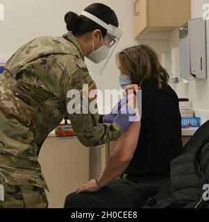 Illinois Army National Guard Medic SPC.Lynnette Banvelos, d'Addison, en Illinois, administre un vaccin à un membre de la communauté locale au Centre de santé North Riverside de Cook County Health.Les médecins de l'armée reçoivent environ quatre mois de formation intensive dans les tâches médicales à fort Sam Houston, Texas, y compris l'administration de vaccins.Après leur formation initiale, les médecins sont tenus de certifier à nouveau périodiquement.Dans l'Illinois, les médecins sont certifiés par l'État au niveau de l'EMT, mais leur instruction de l'Armée de terre inclut également des tâches au niveau paramédical plus avancé.Régulateur de l'Illinois JB Pritzker activé Banque D'Images