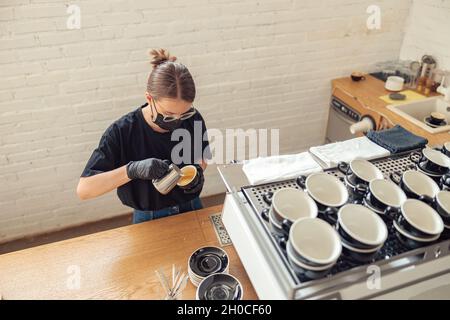 Femme tenant une tasse et utilisant des outils spéciaux Banque D'Images