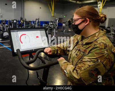 Sergent d'état-major de la Force aérienne des États-UnisHaley Grenier, administrateur du personnel de soutien du commandement au 379e Escadron de communications expéditionnaires, effectue un test de vitesse Internet sur un vélo d'exercice intérieur Peloton au gymnase du complexe Blachford Preston, le 22 janvier 2021, à la base aérienne Al Udeid, au Qatar.Une récente mise à niveau vers le service Wi-Fi à l'échelle de la base a permis d'augmenter les vitesses d'Internet de 14x, améliorant ainsi les options de divertissement, les opportunités éducatives, les programmes de fitness et les connexions familiales pour les membres du service déployés à Al Udeid AB. Banque D'Images