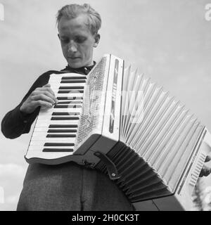 Ein junger Mann der Fotograf Karl Heinrich Lämmel spielt Akkordeon, Deutschland 1930er Jahre.Un jeune homme le photographe Karl Heinrich Lämmel jouant l'accordéon, Allemagne des années 1930. Banque D'Images