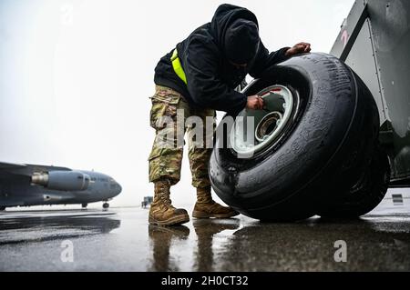 Le principal Airman Elijah Turner, chef d'équipage du 911e Escadron de maintenance d'aéronefs, retire la tige de valve d'un pneu C-17 à la station de réserve aérienne de l'aéroport international de Pittsburgh, en Pennsylvanie, le 26 janvier 2021.L'entretien régulier des pneus permet de s'assurer que l'avion peut atterrir et prendre le décollage en toute sécurité. Banque D'Images